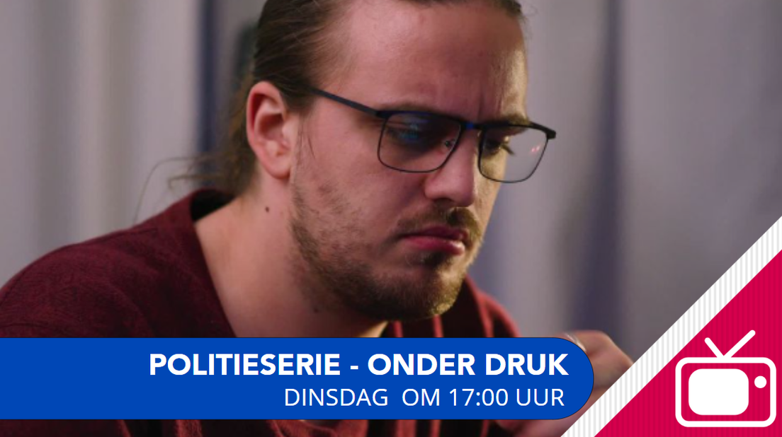 Een man met bril en staart die ernstig kijkt.
